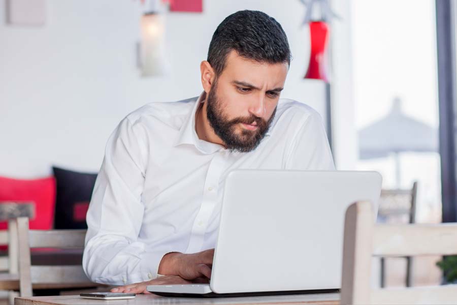 Man sitting in front of his laptop reading intently