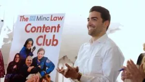 attorney clapping in front of poster